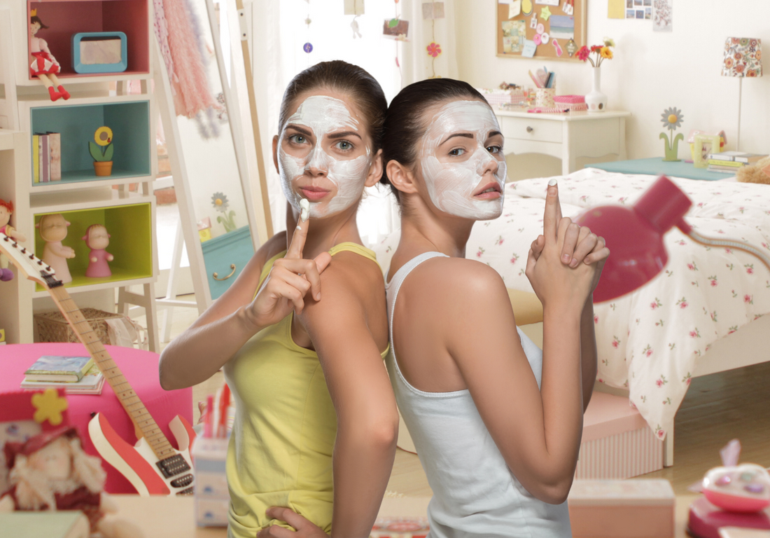 Teen girls with pampering face masks hanging out at a teen sleepover party