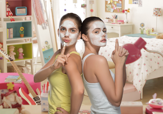 Teen girls with pampering face masks hanging out at a teen sleepover party